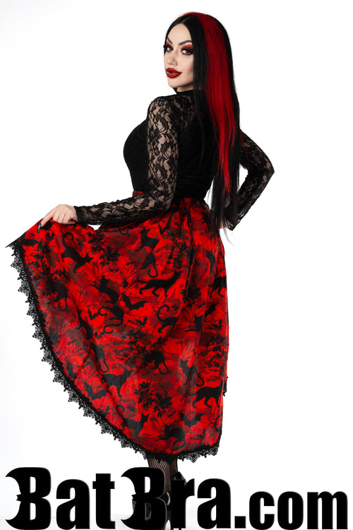 Back view of women's red asymmetrical skirt with bats and cats print showing elastic waist and black lace trim
