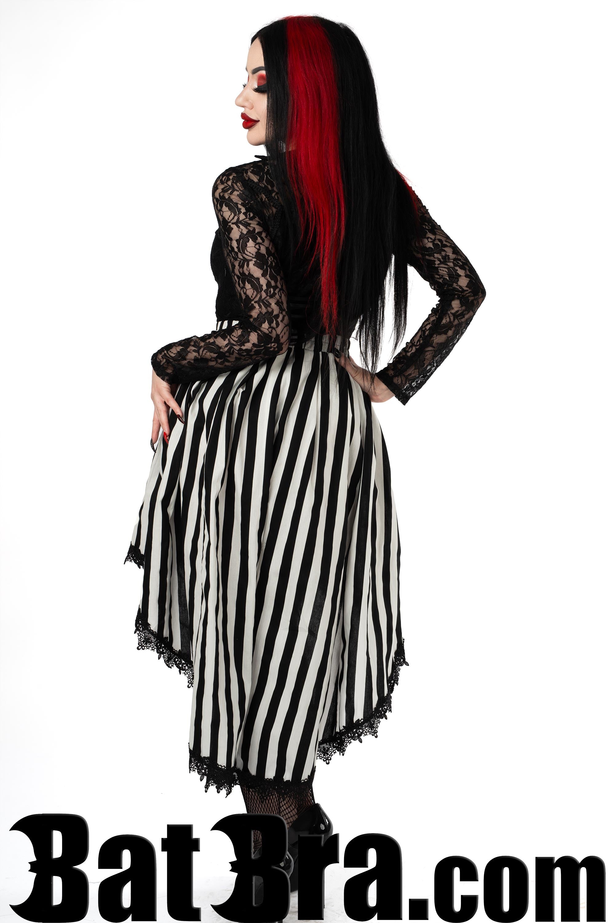 Back view of women's black and white striped asymmetrical skirt showing longer back and black lace trim hem