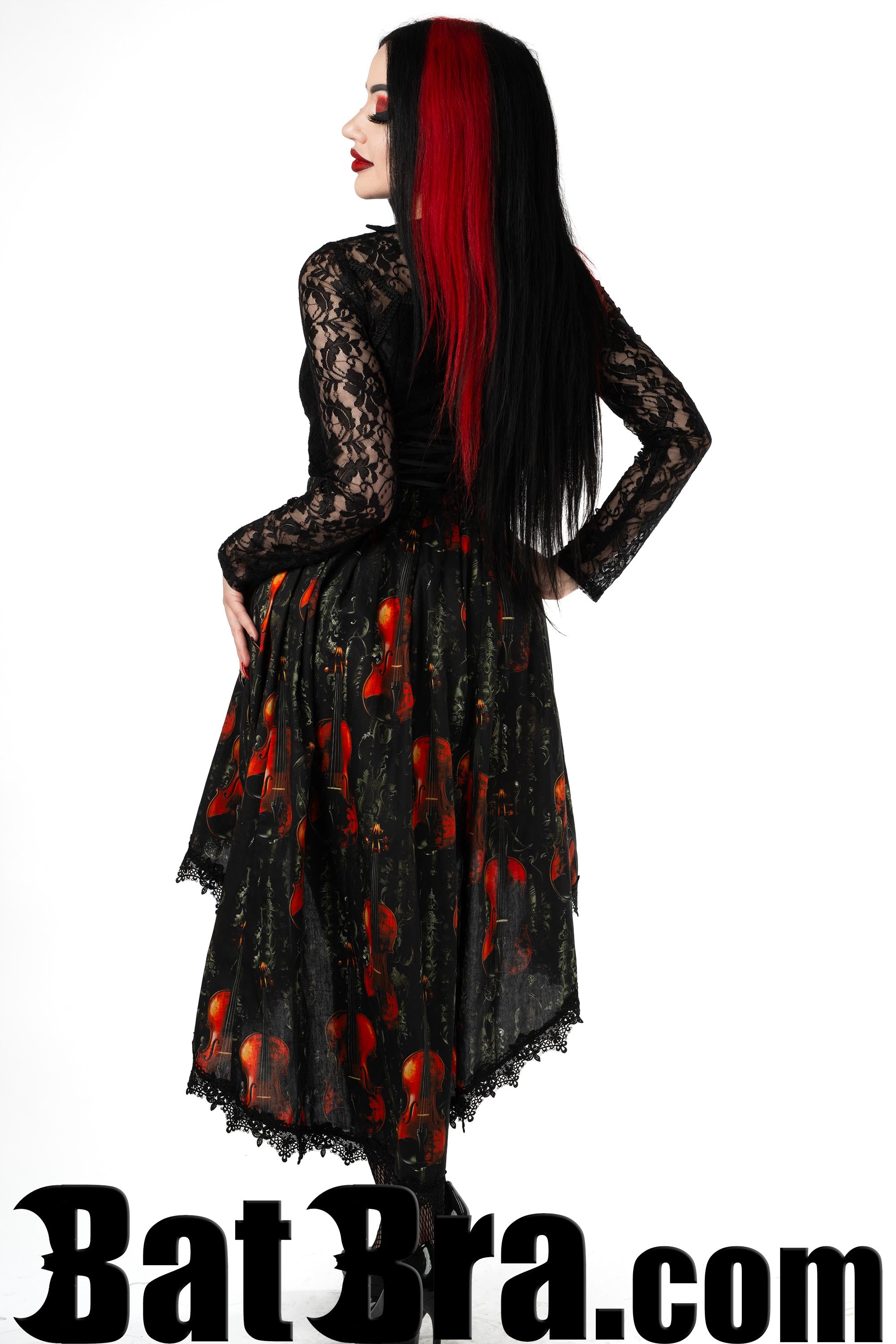 Back view of women's asymmetrical black skirt with violins print showing longer back and black lace trim